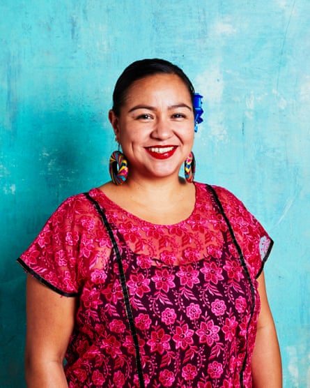 Dark-haired woman standing in front of blue background