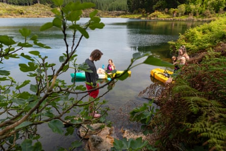 Teenagers visit a hot water vent on Lake Rotoiti to swim.