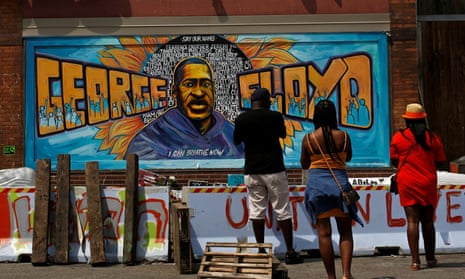 Des membres de la communauté visitent l'une des peintures murales de George Floyd Square, Minneapolis, Minnesota, États-Unis, le 3 juin 2021.