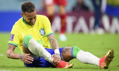 Brazil's Neymar holds his right ankle before being substituted during the match with Serbia.