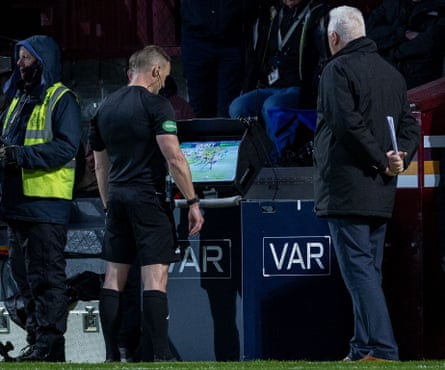 The referee, Steven McLean, checks replays of a challenge on Alexandros Kyziridis