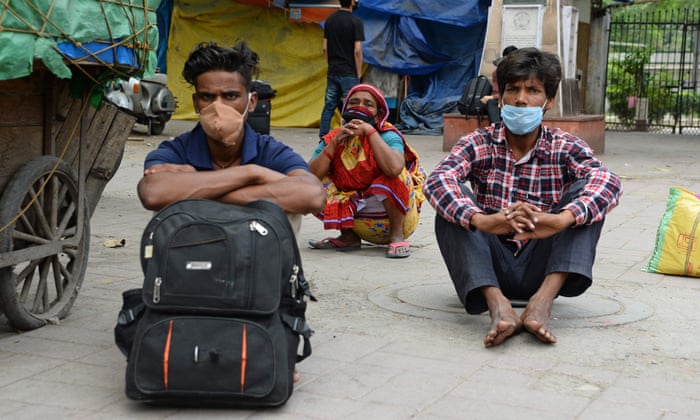 Stranded people who have their train tickets sit outside the railway station in New Delhi.