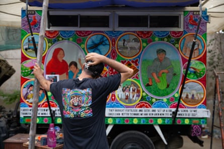 Ali Salman Anchan assesses the progress of the painting of the truck, which is now covered with images of people he has met in the flood-affected areas.