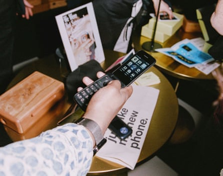 A person holds a flip phone in their hand