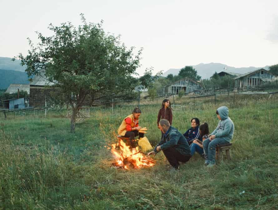 Nata Abashidze and her family sit next to a fire in their garden in the early evening