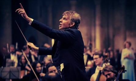 man in black tie conducting an orchestra