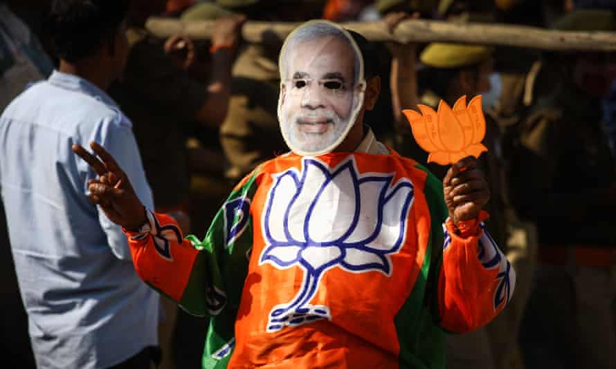 A supporter wears a Narendra Modi mask during a roadshow in support of state elections in Allahabad, India.