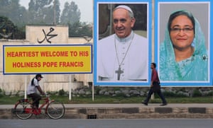 Communters pass a hoarding of images of Pope Francis and Bangladesh prime minister, Sheikh Hasina, ahead of the pope’s arrival in Dhaka