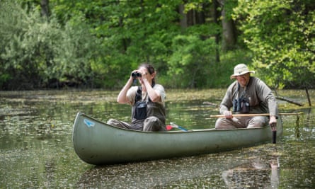 Two naturalists in a canoe on a swamp pool