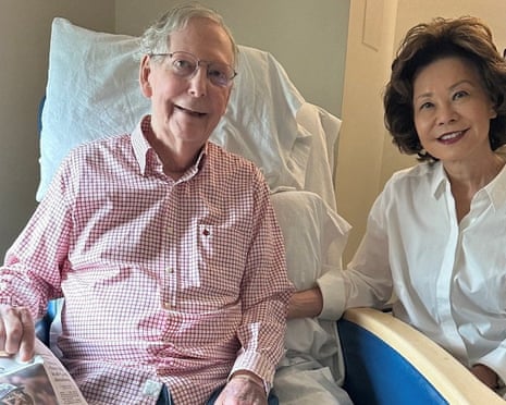 Mitch McConnell sits with his wife, Elaine Chao, while holding what appears to be the 12 July sports section of the Washington Post in a photograph released by his office that same day.