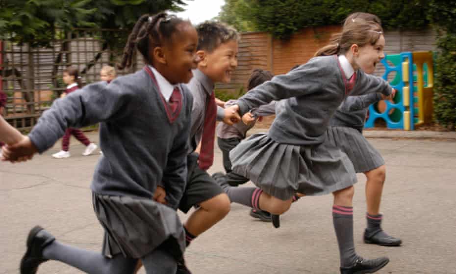 group of children running in the playground of a school