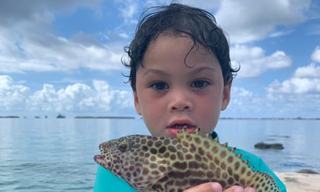 Tarlan Milne-Paul, who is named after an ancient coral head in the Marshall Islands, holds a fish