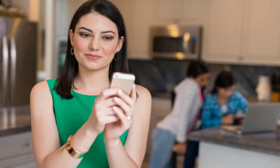 Mother using mobile phone in kitchen