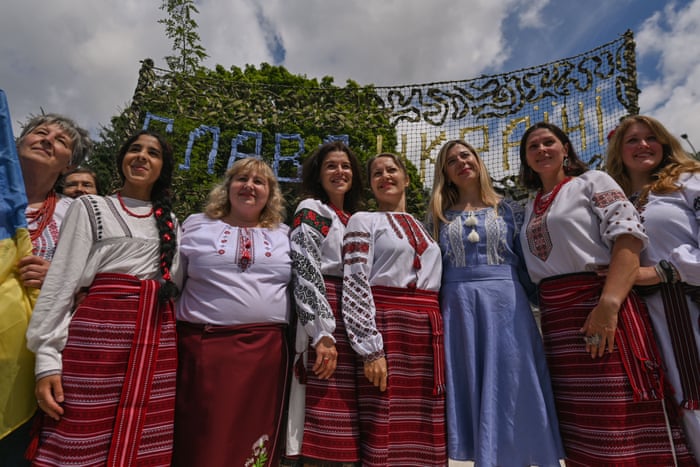 Members of the local Ukrainian diaspora pose for a photo while performing a Ukrainian song near the Russian consulate.