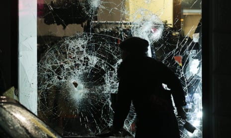 A person prepares to clean up broken glass outside a shop in Leipzig.