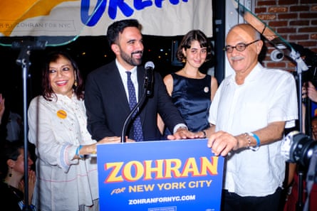 two women and two men smile behind a microphone