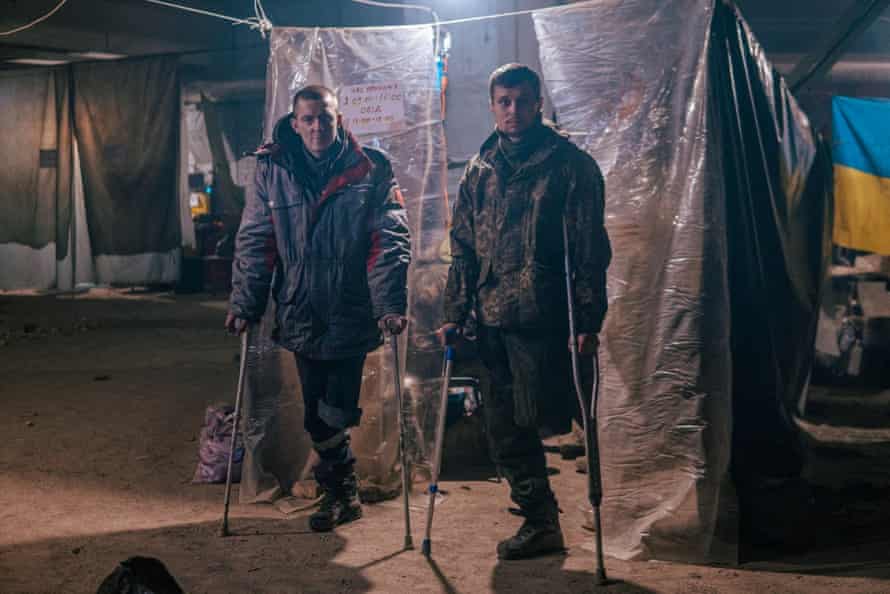 Two men who each mislaid a limb from Russian assaults usage crutches to stand.