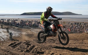 A competior at the top of the highest dune on the course