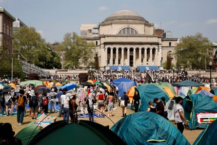 Dozens of students and tents on a dry, hard-packed dirt yard.