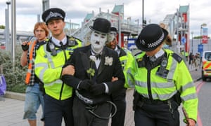 A protester is led away by police