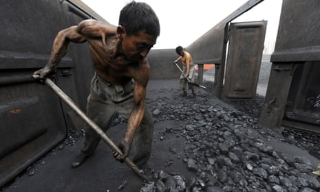 Workers shovel coal at a storage depot in Hefei, China
