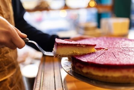 Waiter serving slice of cake at cafeHands of barista serving fresh cake at coffee shop. Waiter serving slice of cake at cafe with a server knife.