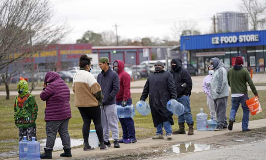 People wait in near freezing temperatures to fill containers with water in Houston.