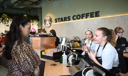 A customer talks to a barista at the counter of a Stars coffee bar, whose decor looks very reminiscent of the US Starbucks chain