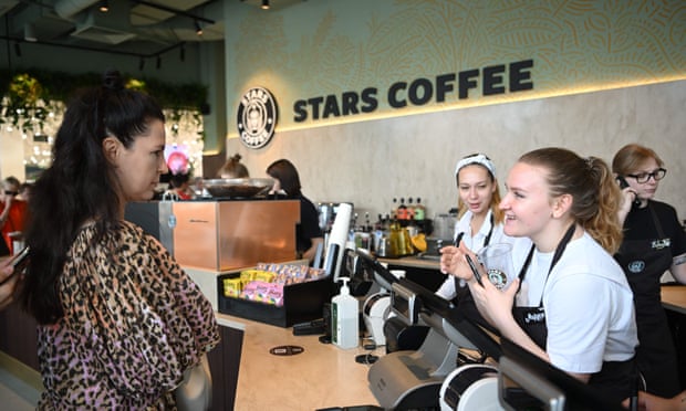 Un cliente habla con un barista en el mostrador de Stars Café, cuya decoración se parece mucho a la cadena estadounidense Starbucks.