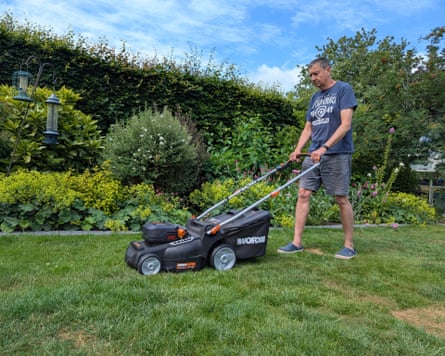 Andy Shaw mows his lawn on a clear day