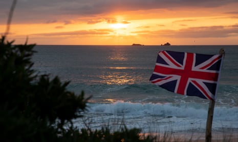 The sun sets behind a Union Jack flag on Constantine Bay beach, Cornwall, on the evening British Prime Minister Boris Johnson announced a ‘road map’ to begin the end of lockdown due after Covid-19.