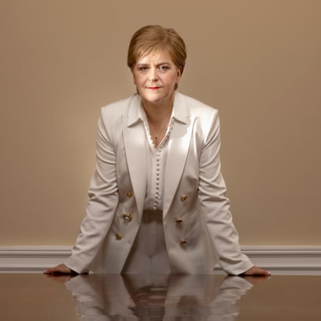 Nicola Sturgeon, photographed in Bute House, Edinburgh, last month, wearing a white suit and blouse, and standing over a shiny table that shows her reflection