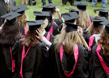 Graduates in caps and gowns wait to be photographed after their degree ceremony