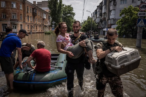 People and their pets are rescued by volunteers and emergency responders in small boats amid flood water