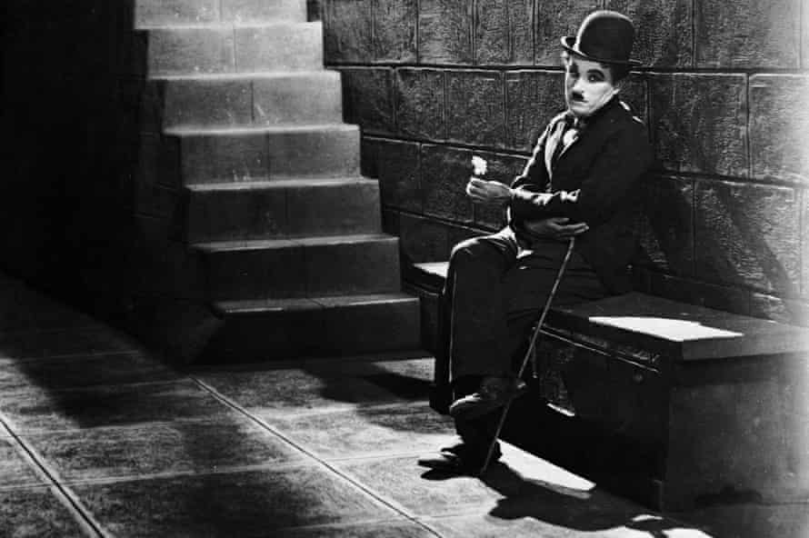 Comic actor Charlie Chaplin sits forlornly at the bottom of steps in a scene from the film 1931 film City Lights