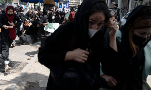 Women running for cover, with one person having fallen over.