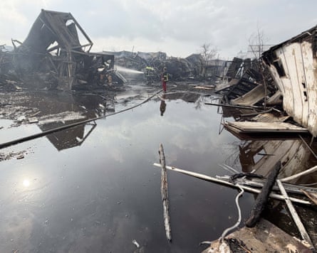 Emergency worker puts out fires in the wreckage of a bombed building