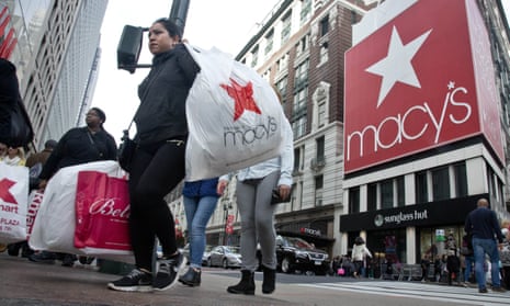 Shoppers carry bags as they cross a pedestrian walkway near Macy’s in Herald Square in New York.