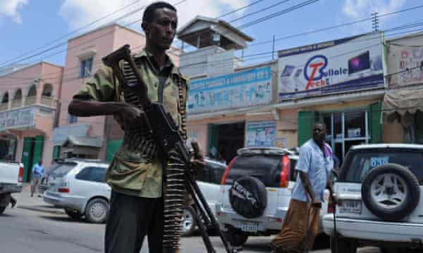 Uomo con mitragliatrice come parte della pattuglia di sicurezza del governo per le strade di Mogadiscio