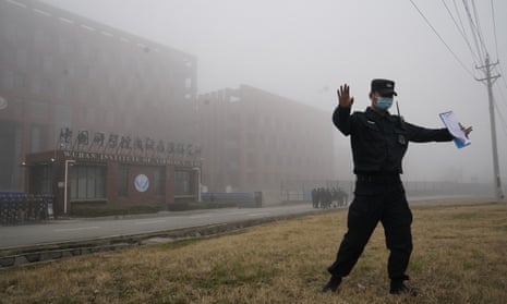 A security official moves journalists away from the Wuhan Institute of Virology 