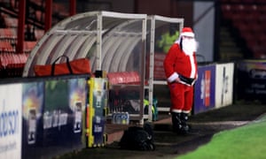 A man wearing a Santa Claus costume in the dug out ahead of the Sky Bet League Two match at Blundell Park, Grimsby.