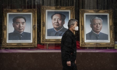 A man passes a picture of Mao Zedong in a nearly empty shopping area in Beijing. The death toll from the coronavirus outbreak has risen to 1,523.