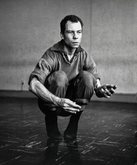 A man crouches down as if dancing