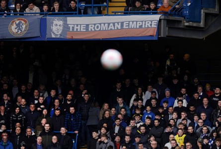 Chelsea fans watch under a banner relating to the ownership of Roman Abramovich during the Premier League match between Chelsea and Newcastle at Stamford Bridge.