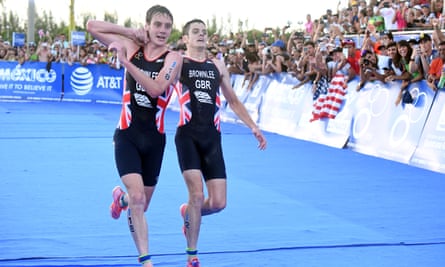 Alistair Brownlee, left, helps his brother Jonny to get to the finish line during the Triathlon World Series event in Mexico in 2016.
