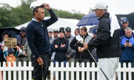 Tiger Woods consults with his caddie on the putting green at Royal Troon