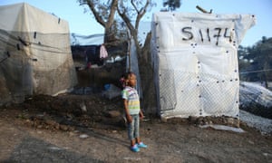 A child next to tents on Lesbos, Greece