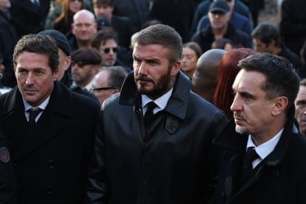 David Beckham and Gary Neville in black suits at a funeral