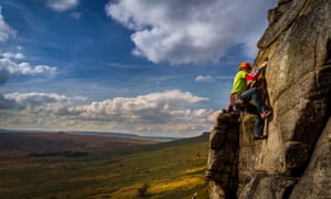 A rock climber on the Stretcher route at Stanage Edge.