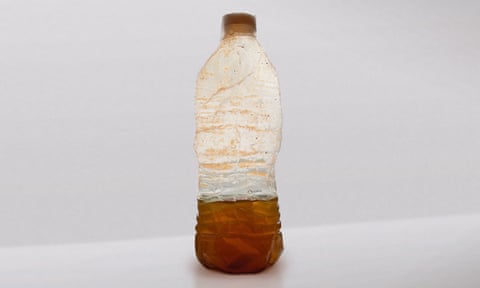 plastic bottle containing discoloured water from a household tap in Flint Michigan